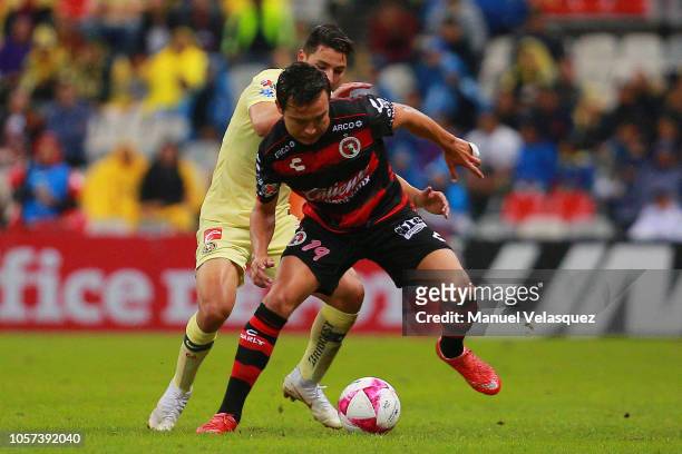 Jorge Sanchez of America struggles for the ball against Erick Torres of Tijuana during the 13th round match between America and Tijuana as part of...