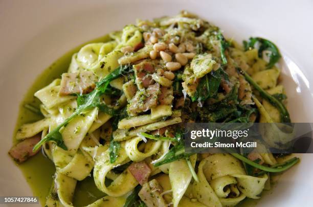 fettuccine pasta with pesto sauce, bacon, pine nuts and arugula - roquette photos et images de collection