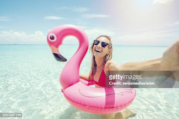 joven toma selfie retrato idílico playa inflable flamingo rosa prístina agua limpia en las islas de tailandia. la gente viaja concepto actitud cool y divertido de lujo - flamingos fotografías e imágenes de stock