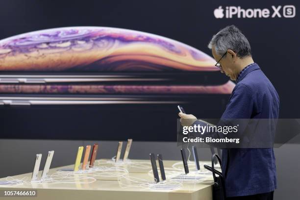 Customer looks at an Apple Inc. IPhone XR smartphone at a SoftBank Group Corp. Store in Tokyo, Japan, on Friday, Nov. 2, 2018. Softbank will announce...