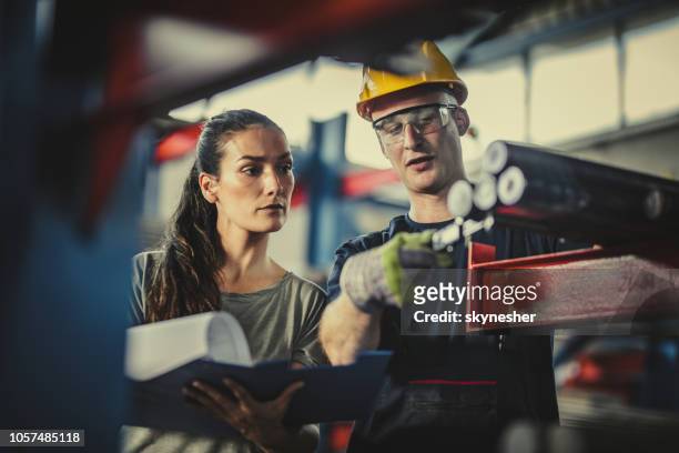 weibliche manager und arbeiter, die analyse von stahl in industriegebäude. - metallindustrie stock-fotos und bilder