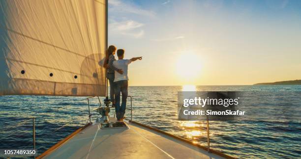 couple staying on edge of prow, croatia - yacht rising sun stock pictures, royalty-free photos & images