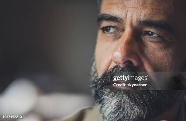 close up of a pensive mature man looking away. - introspection stock pictures, royalty-free photos & images