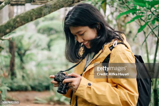若いアジア女性を探索し、ジャングルの中で写真を撮る - インドネシア人 ストックフォトと画像