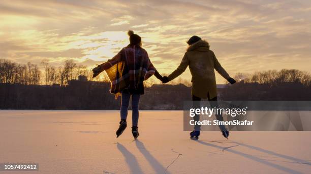 couple skating on frozen lake - ice skating stock pictures, royalty-free photos & images