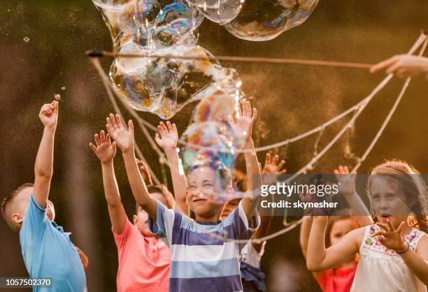 catturare bolle arcobaleno nel parco! - bubble wand foto e immagini stock