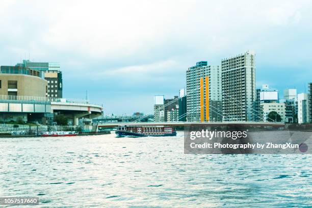 tokyo skyline waterfront view over tokyo bay, with shin ohashi bridge, skyscrapers, houseboats, high way, chuo ward, tokyo, japan at day time before strom. - chuo ward tokyo stockfoto's en -beelden