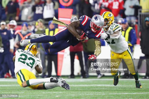 Josh Gordon of the New England Patriots is tackled by Jaire Alexander and Josh Jones of the Green Bay Packers during the second half at Gillette...