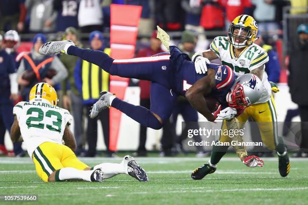 Josh Gordon of the New England Patriots is tackled by Jaire Alexander and Josh Jones of the Green Bay Packers during the second half at Gillette...