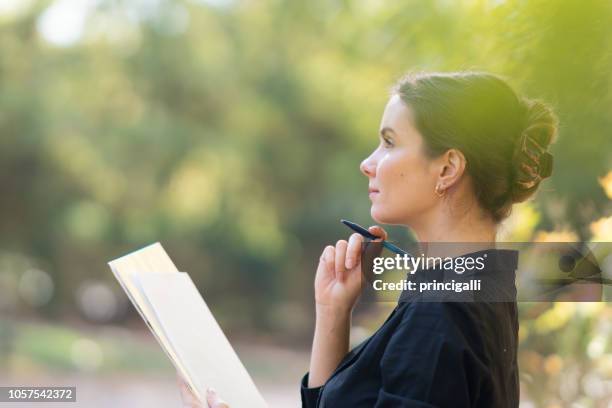 weibliche unternehmer oder student mit stift und papier im park - message stock-fotos und bilder