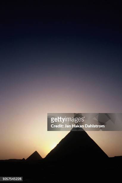 sunset at the pyramids of giza - silhuett foto e immagini stock