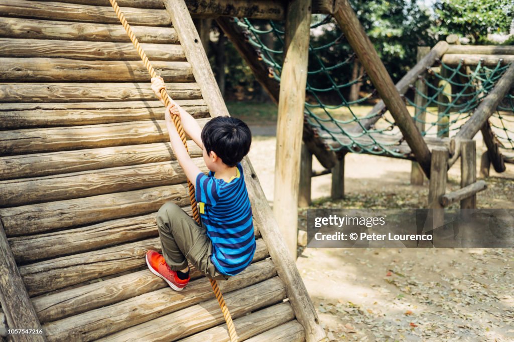 Young boy climbing rope