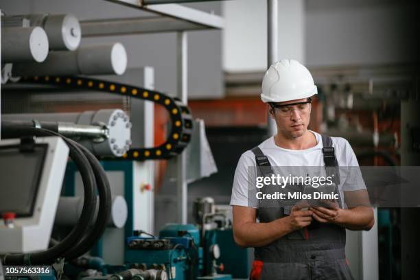 mannelijke ingenieur in fabriek met behulp van tablet pc - machinery stockfoto's en -beelden