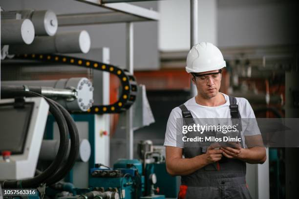 male engineer in factory using tablet - machinery stock pictures, royalty-free photos & images