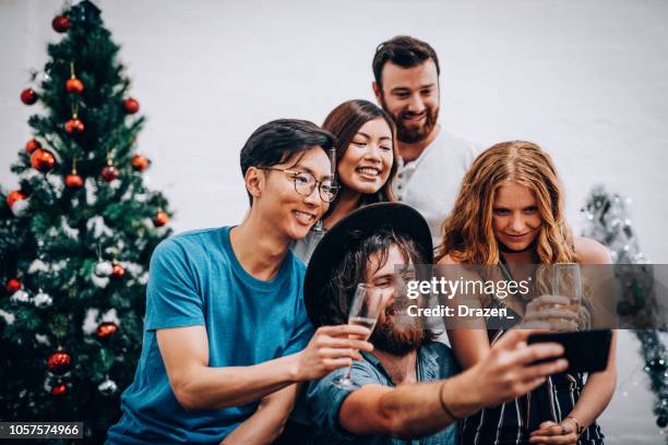 multi-ethnic group of friends celebrate christmas in australia and taking selfie - summer christmas stock pictures, royalty-free photos & images