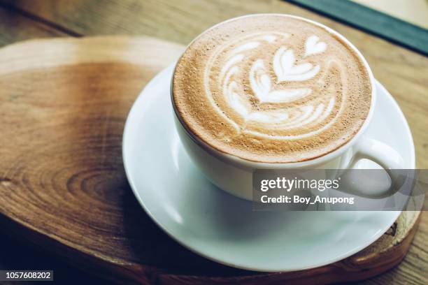 close-up of a cup of hot latte coffee on the wooden table. - coffee break fotografías e imágenes de stock