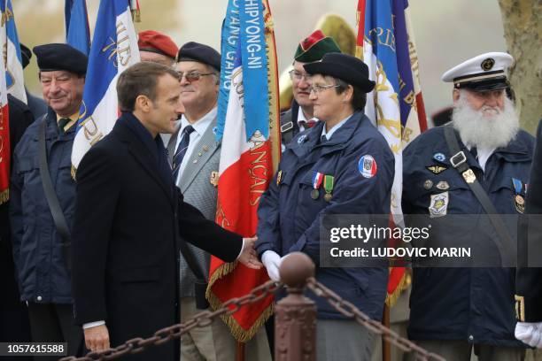 French President Emmanuel Macron greets a member of the Groupement des Porte Drapeaux Metz during a ceremony in tribute to the French soldiers killed...