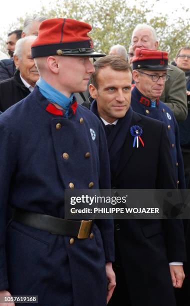 French President Emmanuel Macron poses with history enthusiasts, dressed with vintage army uniforms as Poilu , following a tribute ceremony at the...