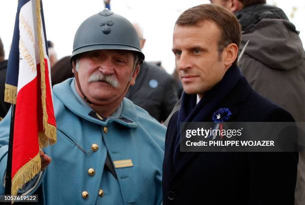 French President Emmanuel Macron listens to an history enthusiast, dressed with vintage army uniforms as Poilu , following a tribute ceremony at the...