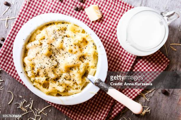 traditional american food. baked macaroni and cheese also called mac and cheese on a wooden table, top view. comfort food. hearty food. - ganges stock-fotos und bilder