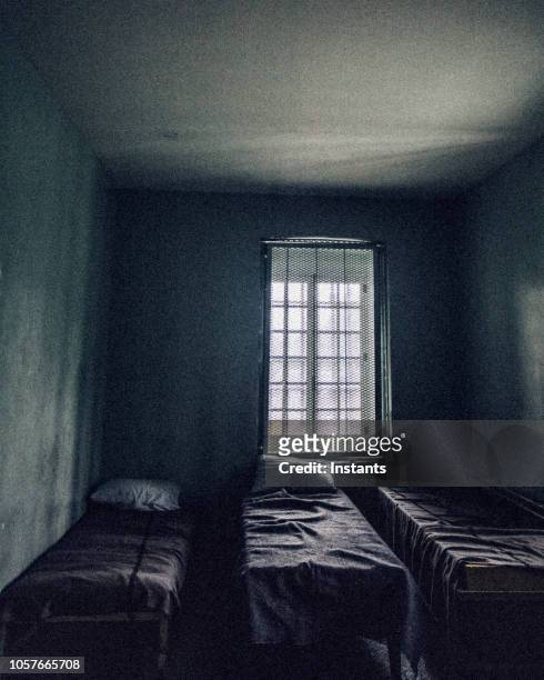 glimpse at an old jail cell interior. - jail bed stock pictures, royalty-free photos & images