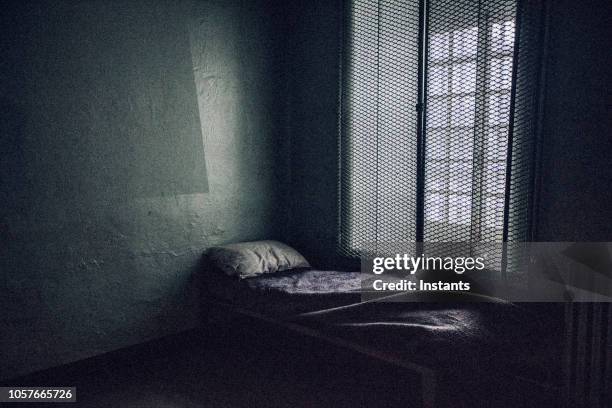 glimpse at an old jail cell interior. - prison cell stock pictures, royalty-free photos & images