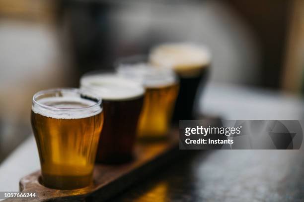 nahaufnahme einer vielzahl von bieren, auch bekannt als ein bier flug, wie in einer kleinbrauerei serviert. - stoutbier stock-fotos und bilder