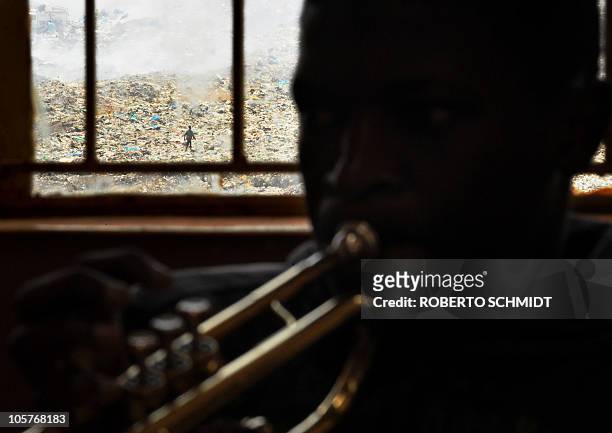 Seventeen-year-old Steve Odieno blows into a trumpet during band practice at a local school in the Korogocho slum in Nairobi on October 16, 2010 as...