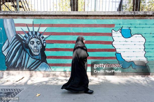 Woman walks in front of anti-American revolutionary graffiti on Taleqani Street in Tehran, the capital of Islamic Republic of Iran on September 27,...