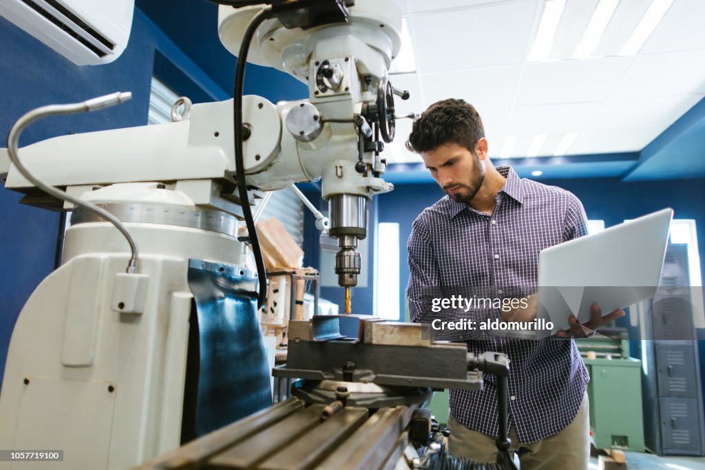 Young latin engineer calibrating drill