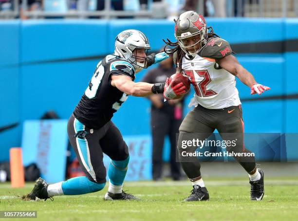 Luke Kuechly of the Carolina Panthers tackles Jacquizz Rodgers of the Tampa Bay Buccaneers during their game at Bank of America Stadium on November...
