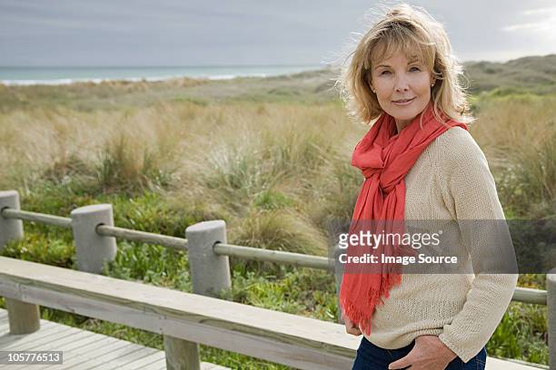woman at the coast - red scarf stock-fotos und bilder