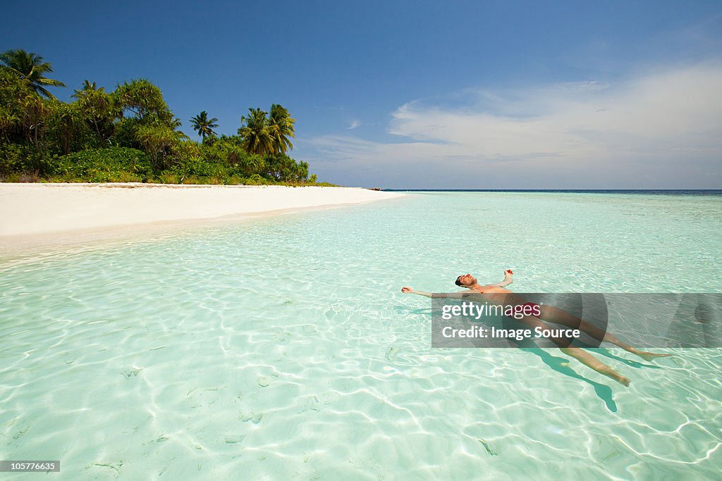 Man floating in sea, Baughagello Island, South Huvadhu Atoll, Maldives