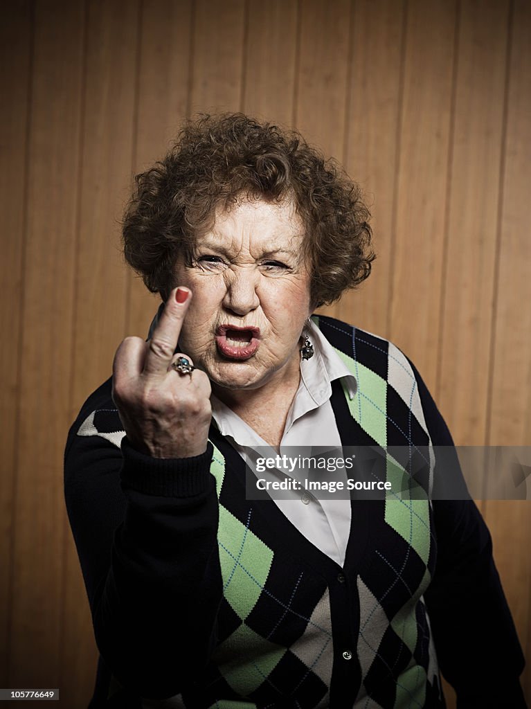 Senior woman making obscene gesture