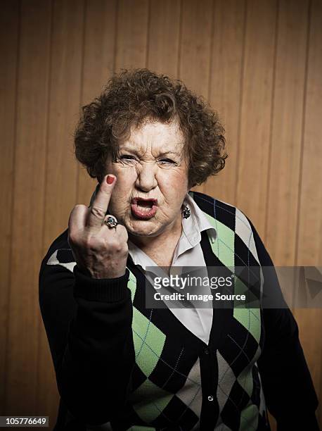 senior woman making obscene gesture - obscene gesture fotografías e imágenes de stock