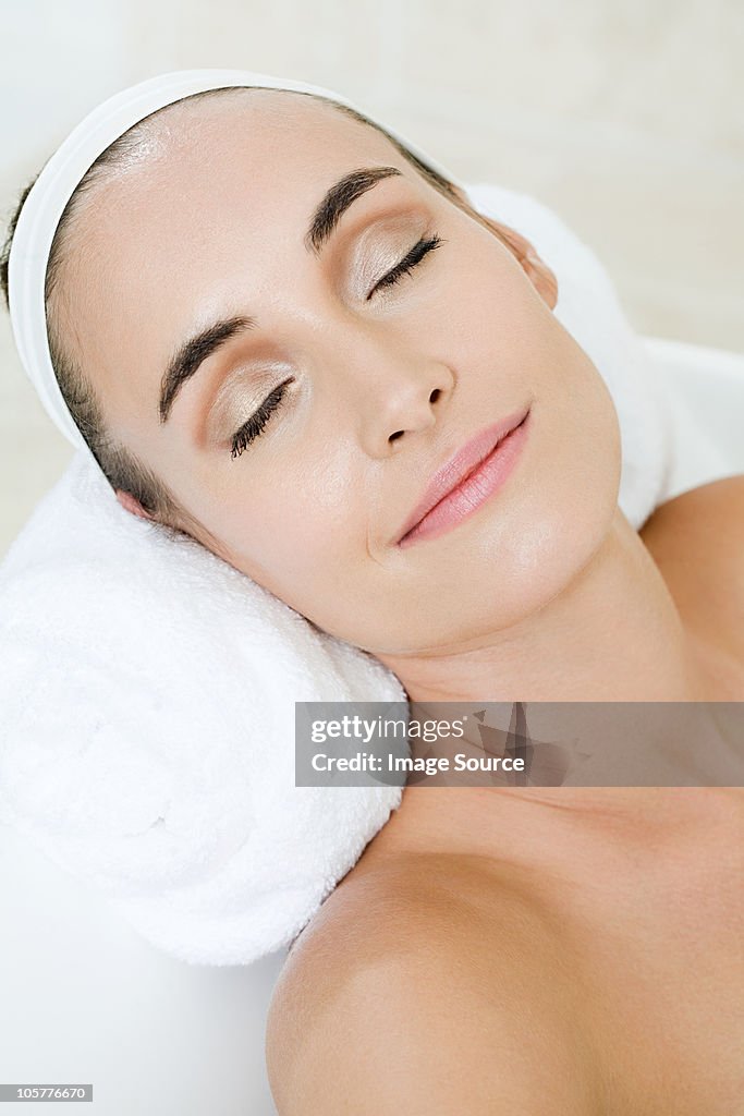 Young woman relaxing in the bath with eyes closed