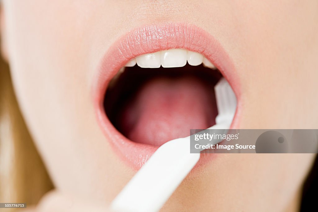 Young woman brushing teeth