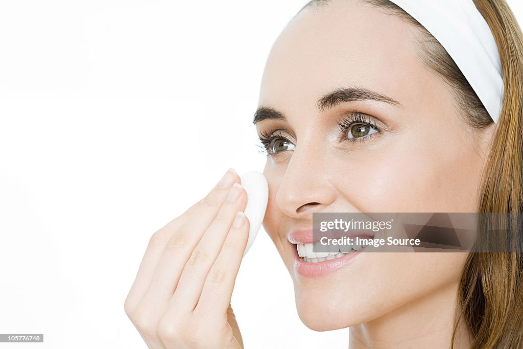 Young woman applying moisturiser