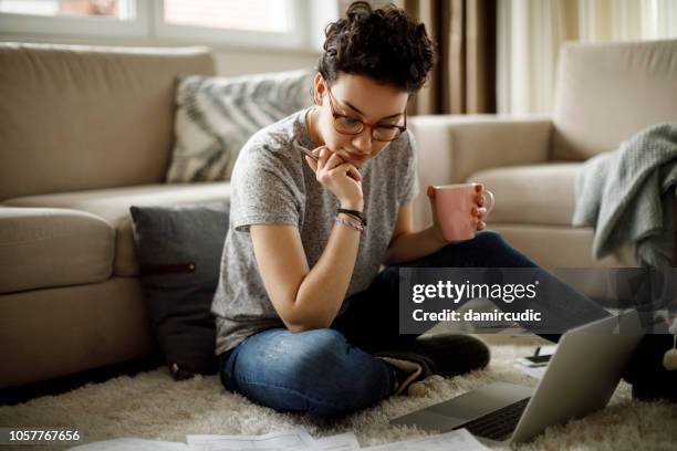 jeune femme travaillant à la maison - femme facture photos et images de collection