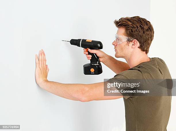 young man using electric drill - drill stock pictures, royalty-free photos & images