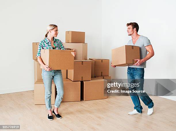 young couple moving boxes - carrying box stock pictures, royalty-free photos & images