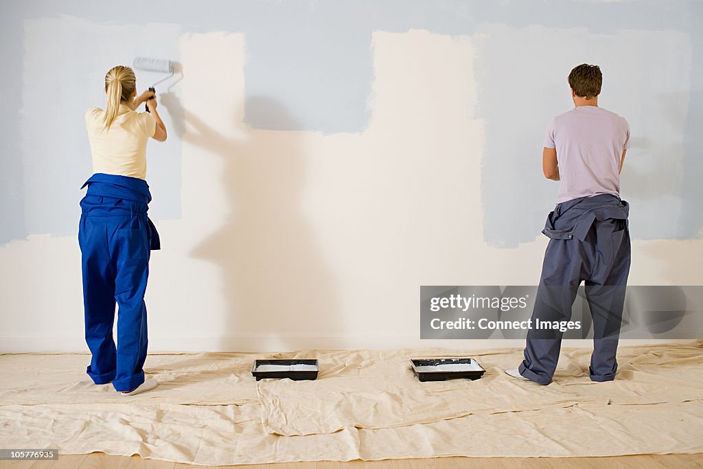Jovem Casal Pintando uma parede