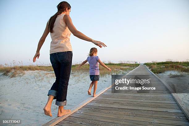 mother and daughter walking on beach walkway - hilton head photos et images de collection