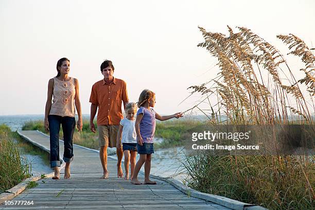 family walking on beach walkway - hilton head photos et images de collection