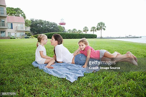 happy mother and daughters lying on grass - hilton head stock pictures, royalty-free photos & images