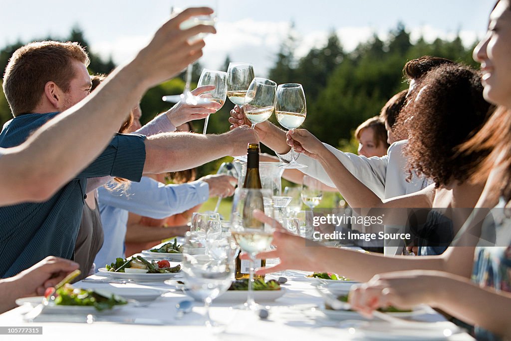 Pessoas mais as taças de vinho no jantar ao ar livre