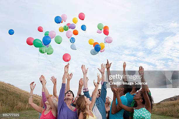 young people releasing balloons - frige bildbanksfoton och bilder