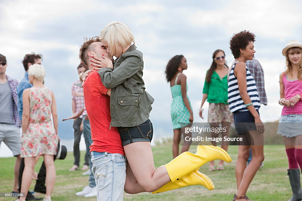Jovem levantando sua namorada e Beijar no festival