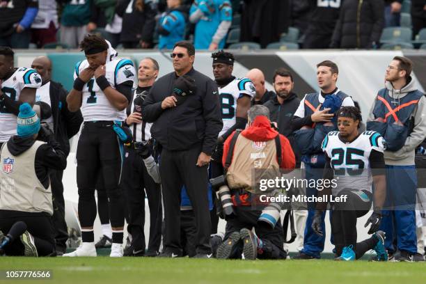 Cam Newton and head coach Ron Rivera of the Carolina Panthers stand for the national anthem while Eric Reid takes a knee prior to the game against...