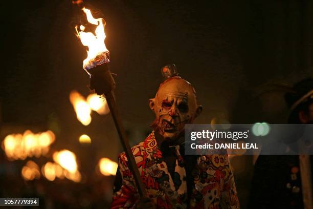 Masked reveller carries his torch through the streets of Lewes in East Sussex, southern England, on November 5 during the traditional Bonfire Night...